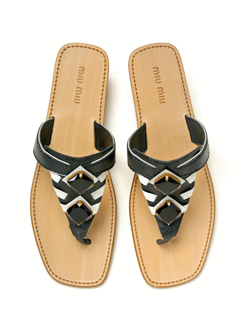 Black and white toe sandals with straps on white background