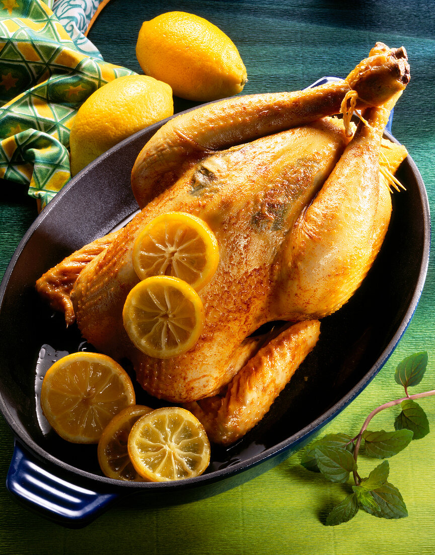 Lemon chicken with lemon slices in roaster