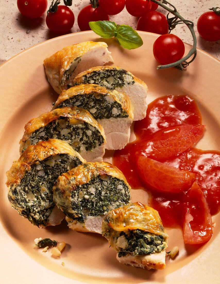 Close-up of chicken breast stuffed with tomatoes and spinach on plate