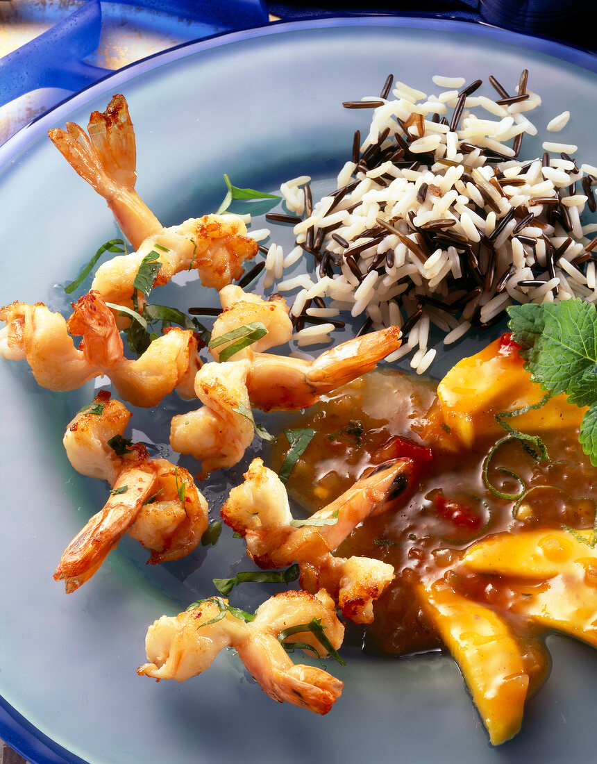 King prawns with mango sauce and rice on blue plate