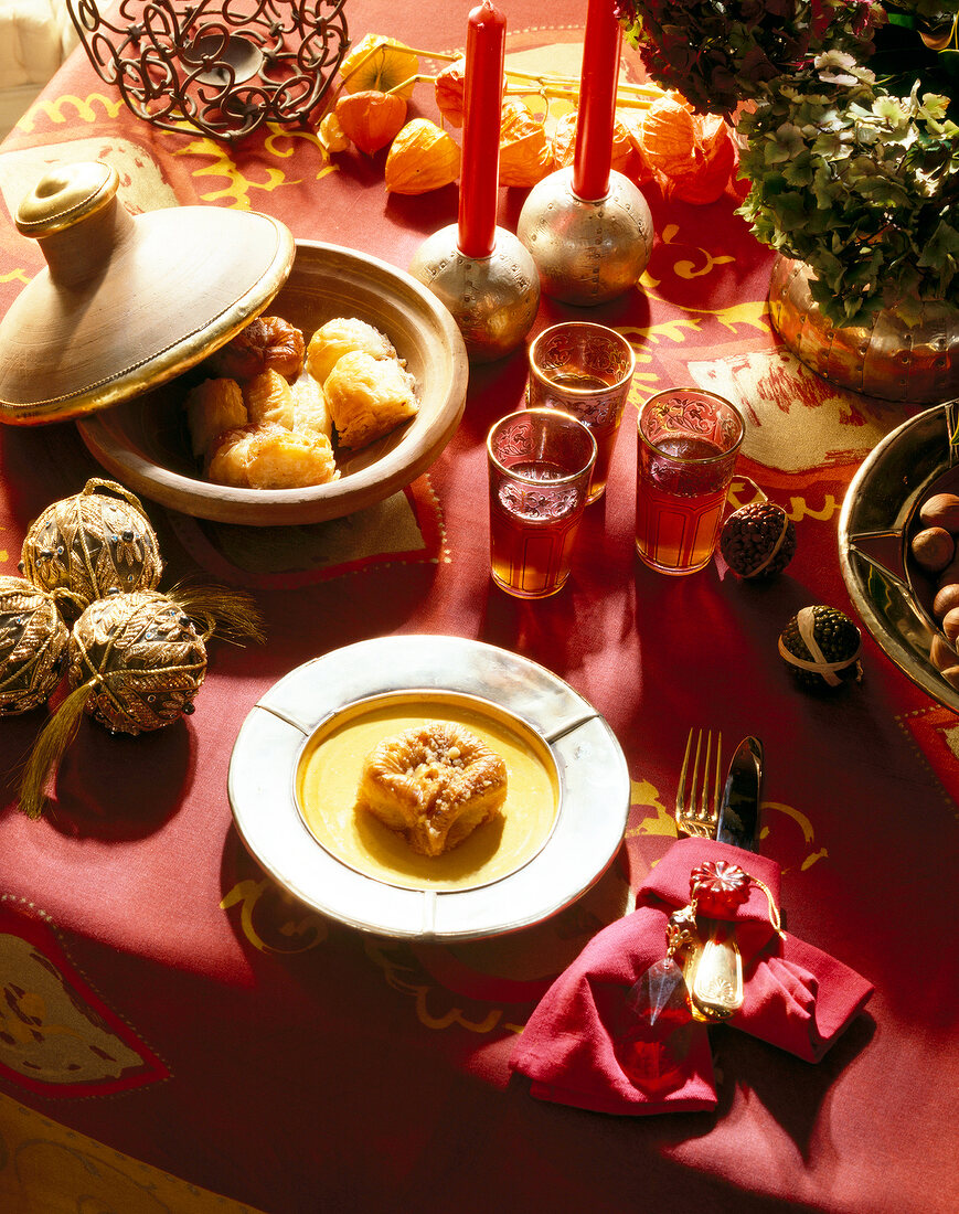 Close-up of table festively decorated in red with dishes and glasses