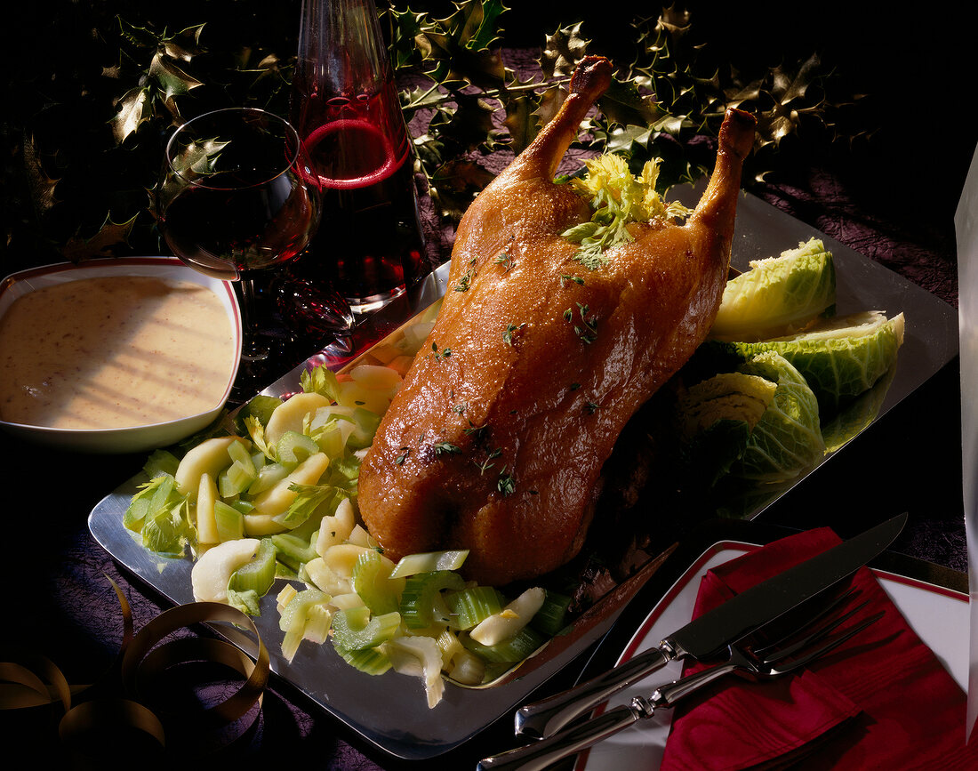 Stuffed roast goose with date sauce and vegetables for Christmas dinner