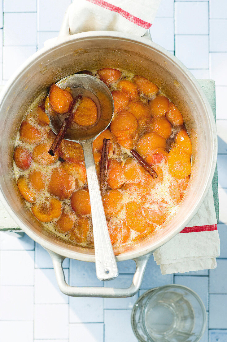 Apricot jam with cinnamon in pot, overhead view