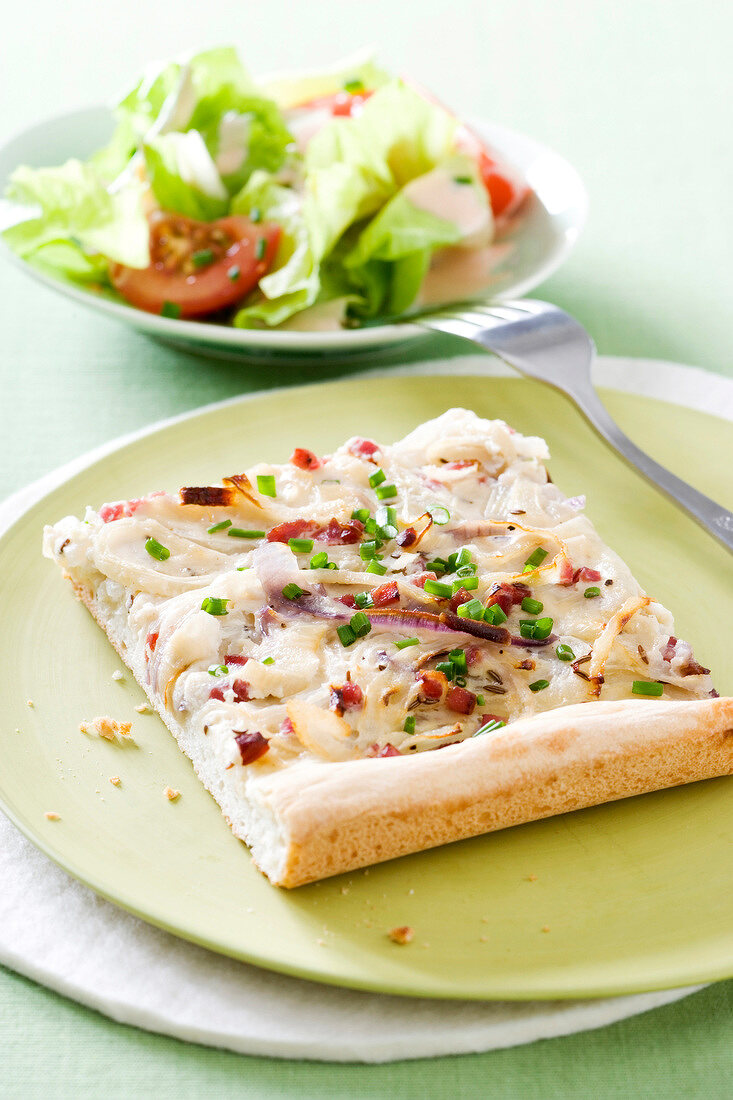 Close-up of ham with chives and pieces of onions on plate