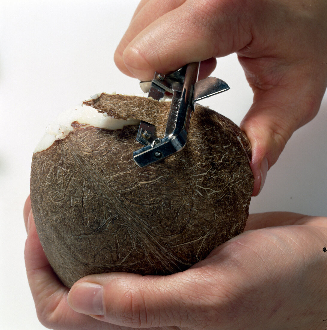 Peeling skin of coconut with peeler, step 4