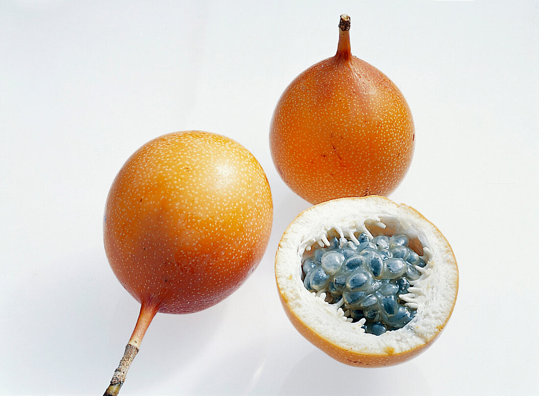 Whole and halved granadilla on white background