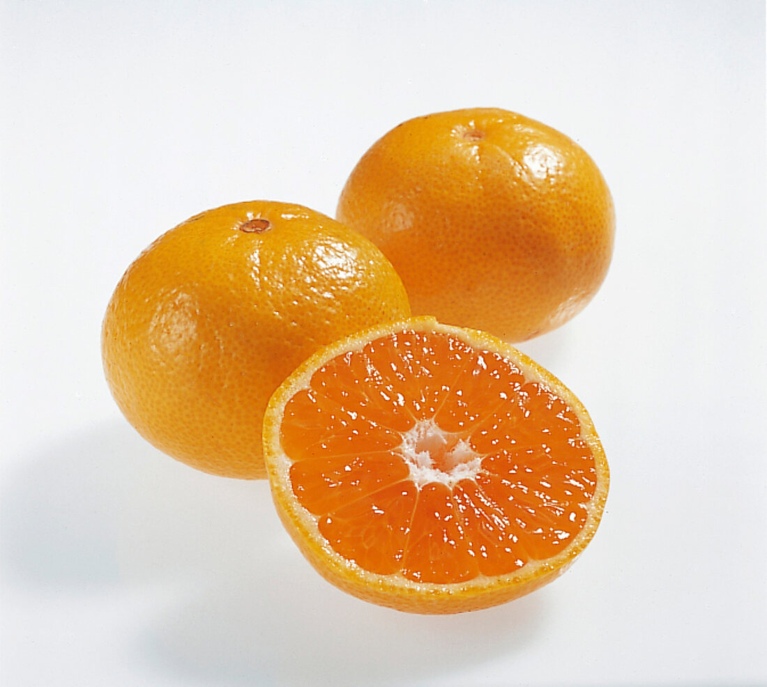 Whole and halved clausellina orange on white background