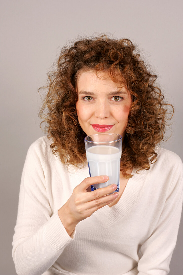 Woman holding glass of milk in hand