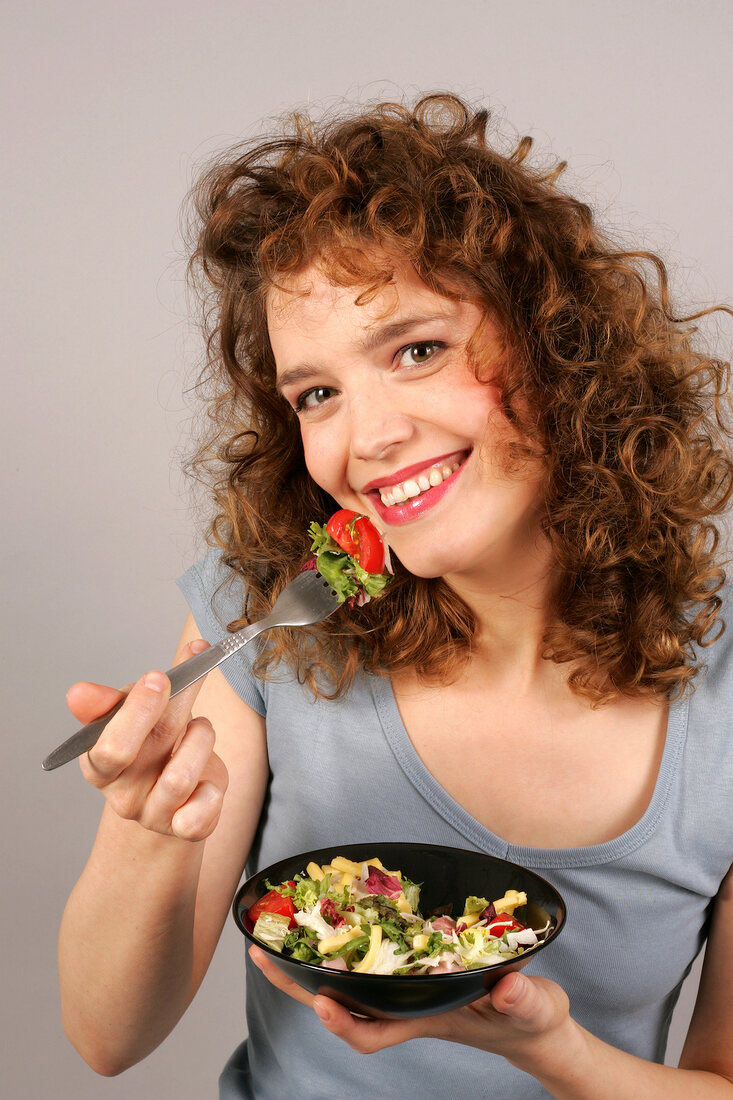 Woman holding bowl with salad in hand