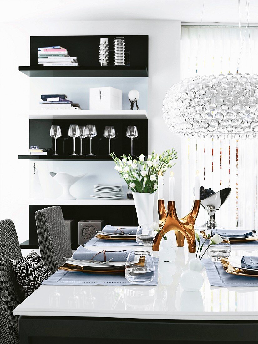 Esszimmer in Schwarz, Weiß & Grautönen mit elegant gedecktem Glastisch & Kristallhängeleuchte