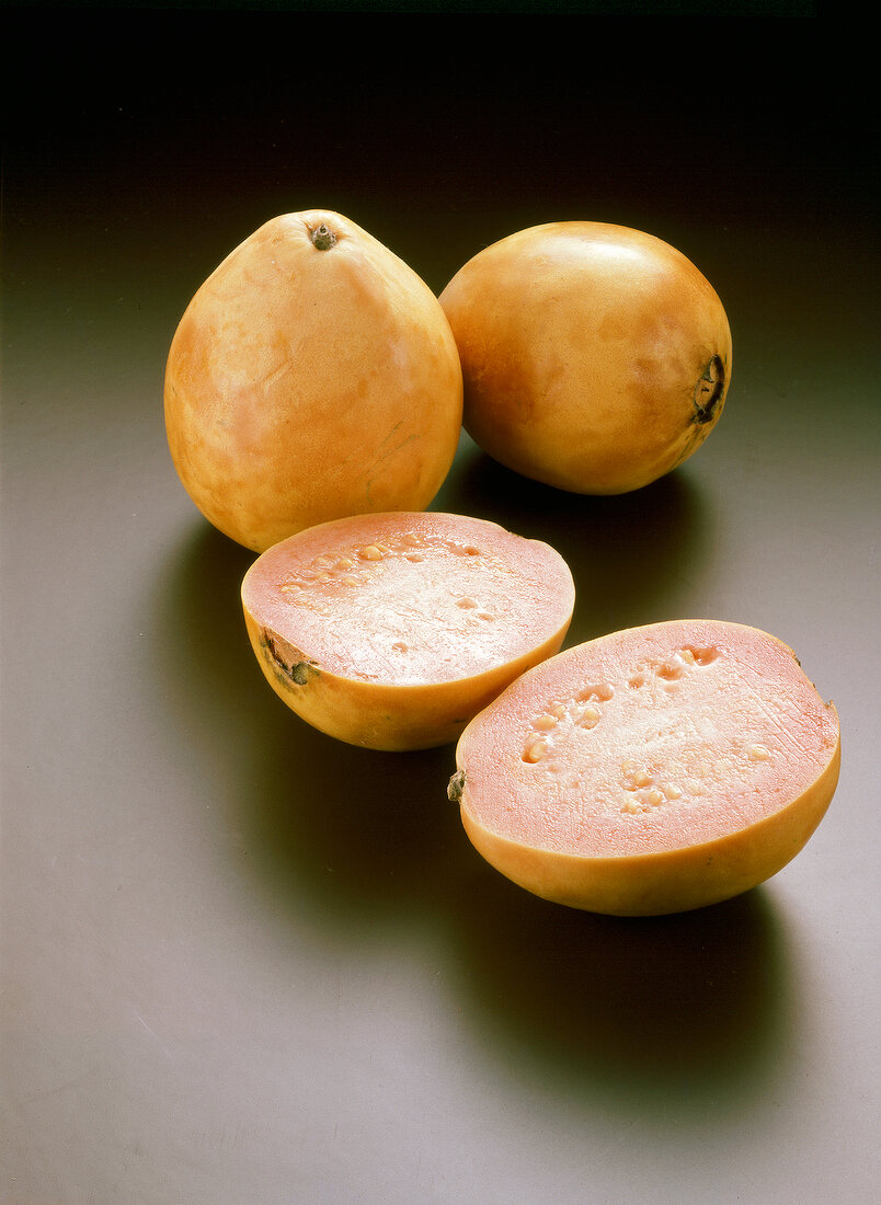 Whole and halved yellow guavas