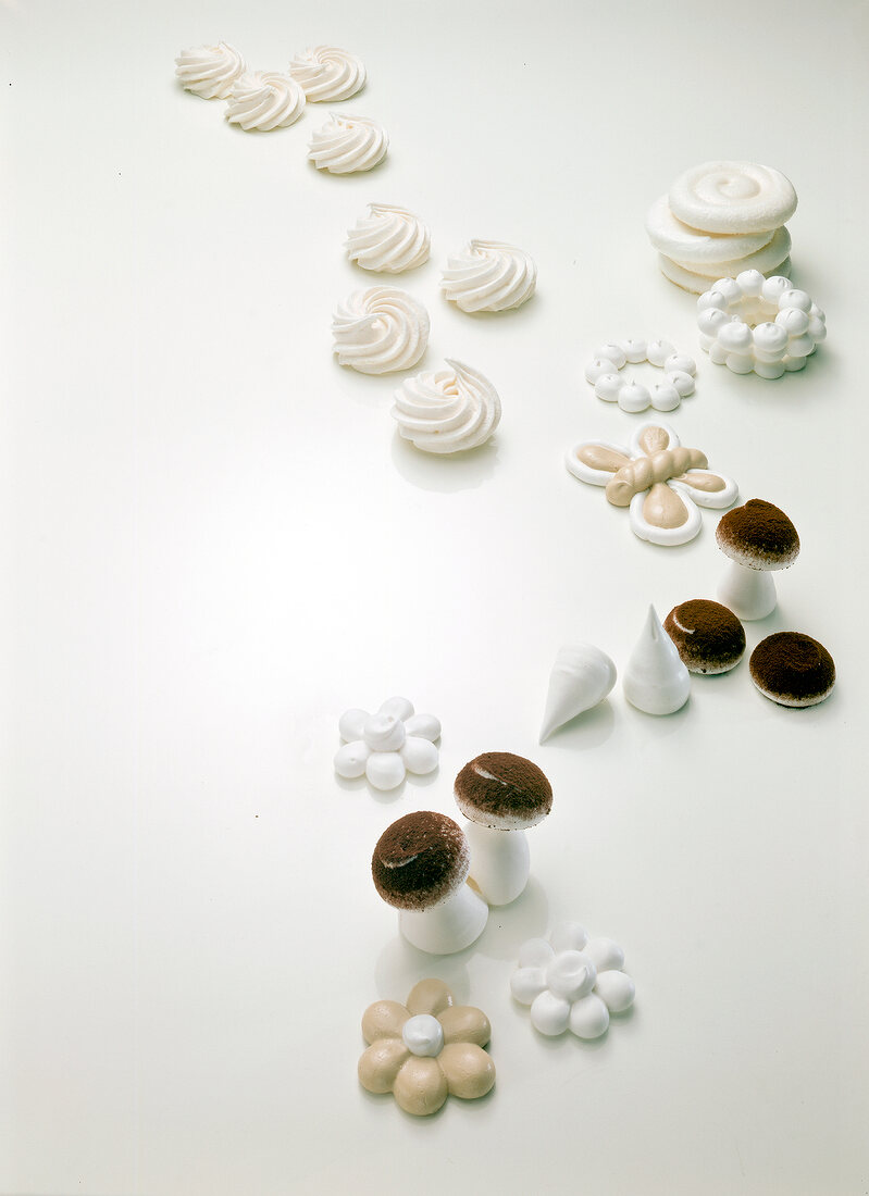 Meringues in various forms on white background