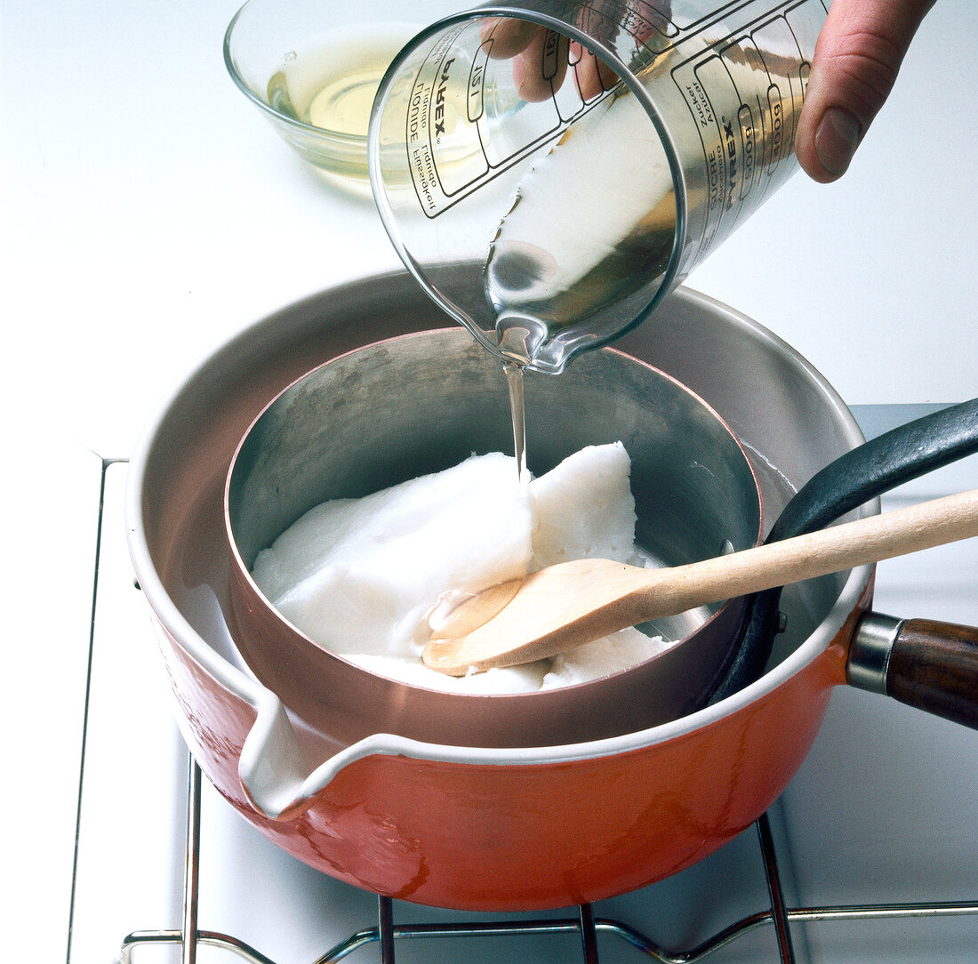 Sugar syrup being poured in pot for preparation of fondant, step 1