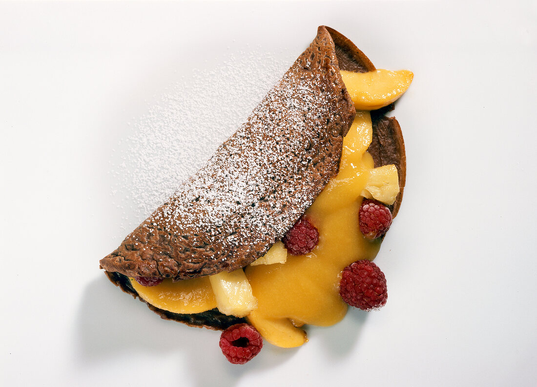 Chocolate crepes with fruits on white background