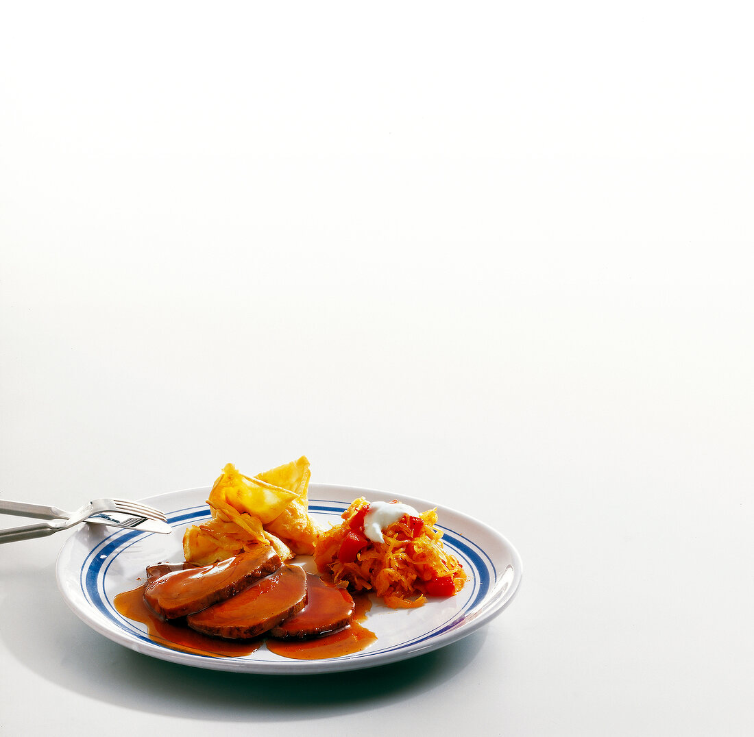 Slices of boar meat with pepper cabbage on plate, copy space