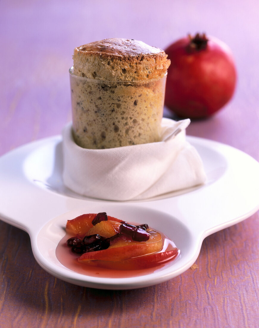 Close-up of hazelnut souffle with pomegranate compote on serving dish