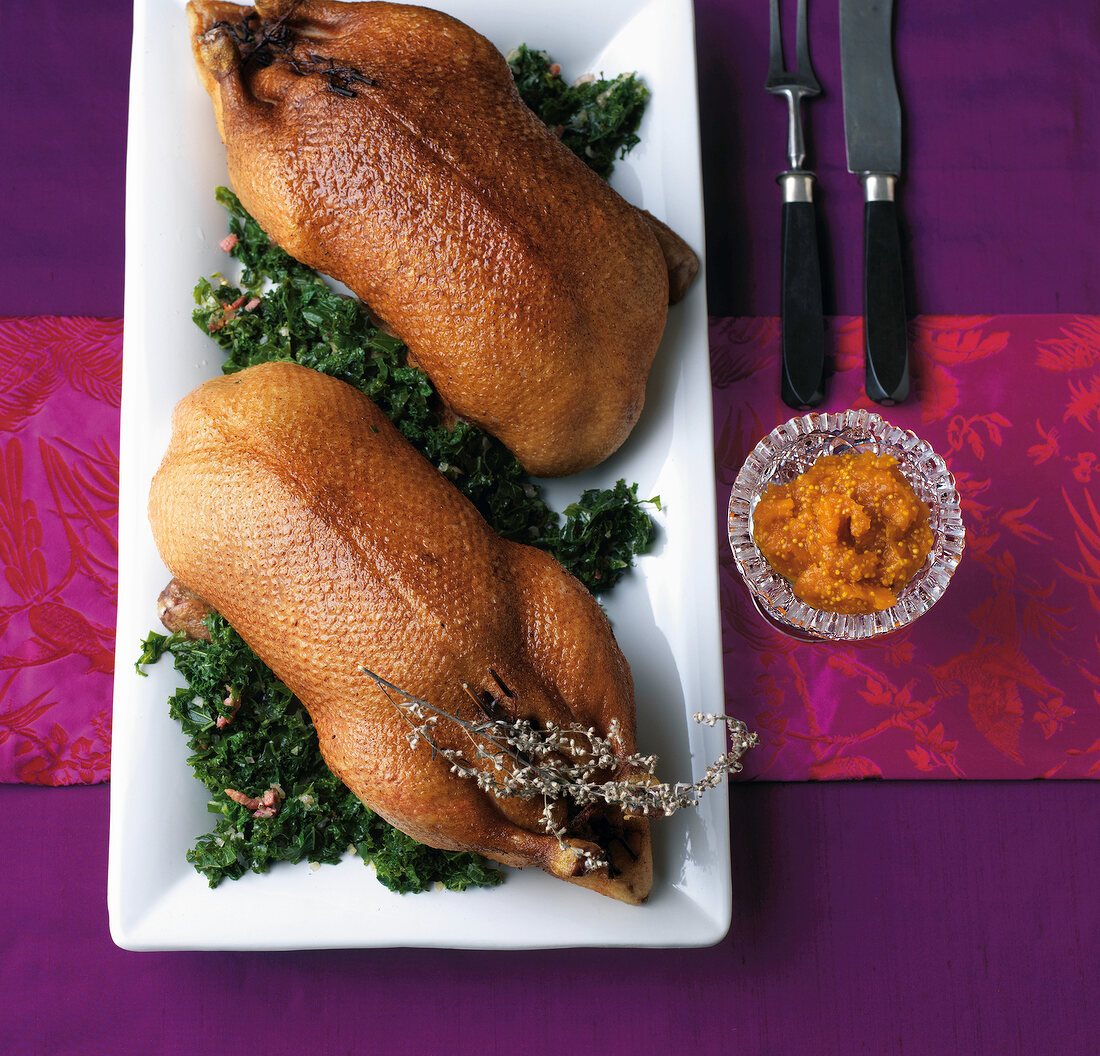 Two roasted goose with kale on plate