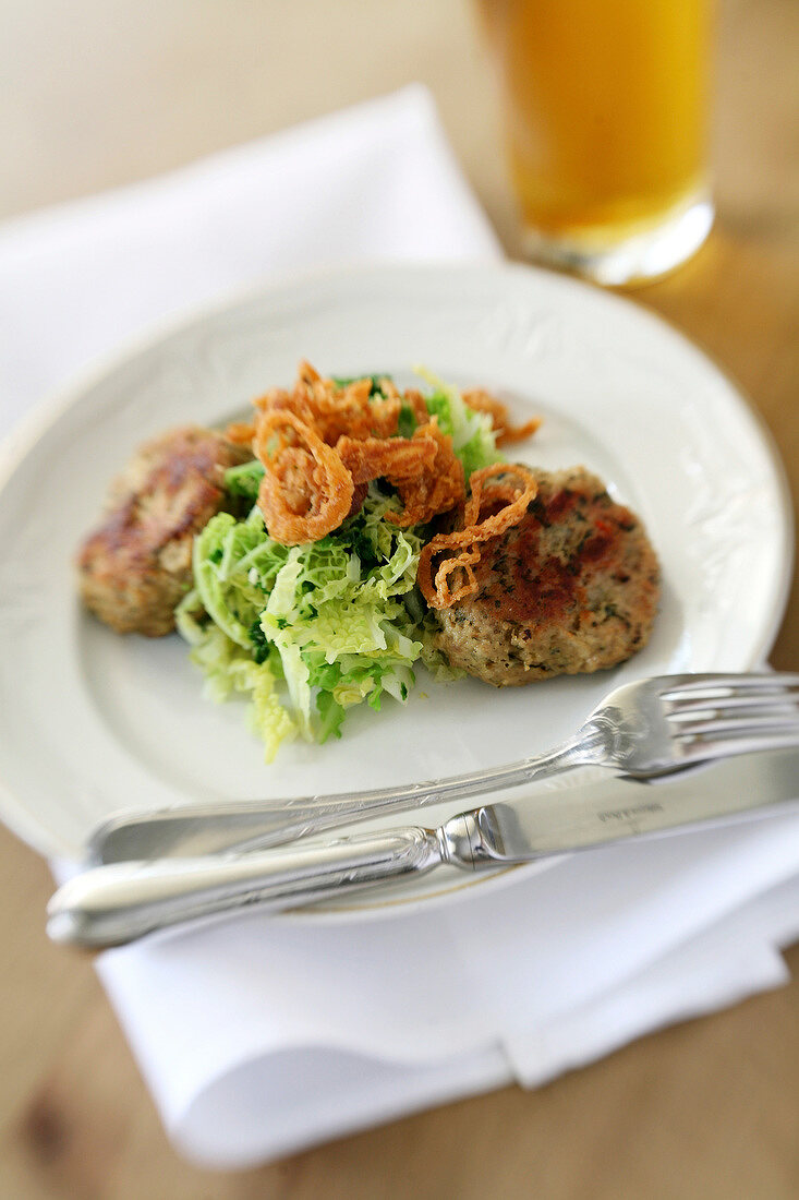 Close-up of meatballs with savoy cabbage and fried onions on plate