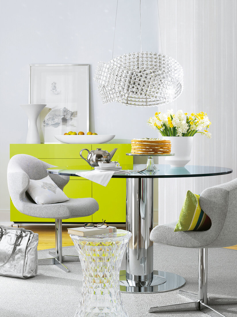 Glossy metal table and chairs in room in grey and green