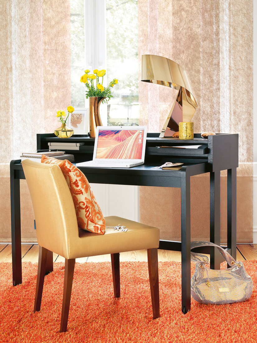 Black work desk with chair in orange and gold colour accents