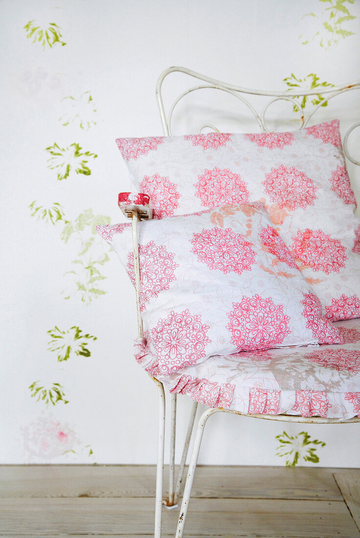 Pink and white floral patterned cushions on metal chair