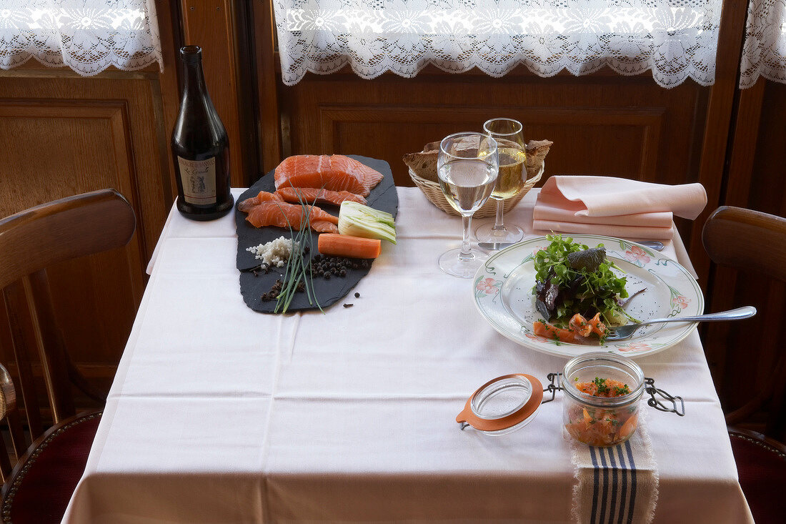 Marinierter Lachs mit buntem Salat, Wein und Wasser