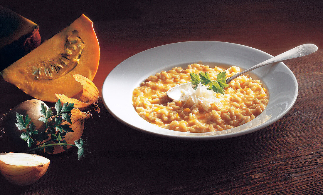 Pumpkin risotto with parmesan cheese, onions and parsley on plate