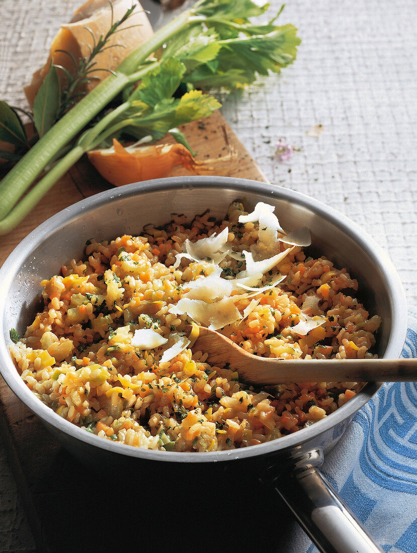 Vegetable risotto with celery, onion, carrots and parmesan cheese in sauce pan