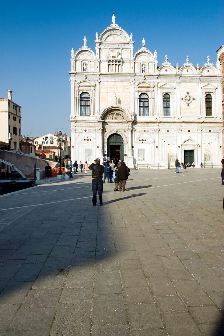 Tourist and Scuola Grande di San Marco at Campo San Giovanni e Paolo square, Venice, Italy