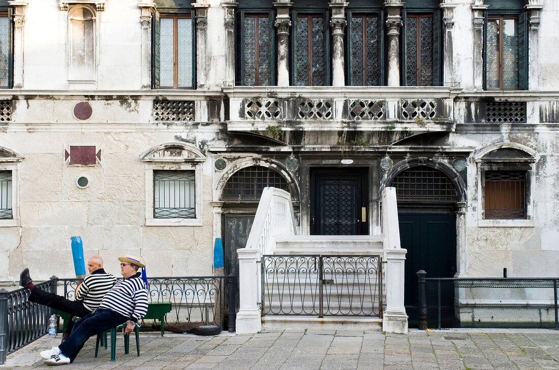 Two gondoliers relaxing in Campo Santa Maria, Venice, Italy