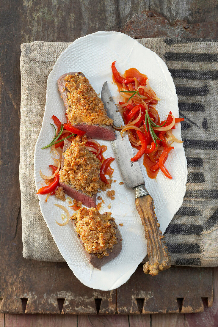 Lammrücken mit Ziegenkäse-MandelKruste auf Teller, rot