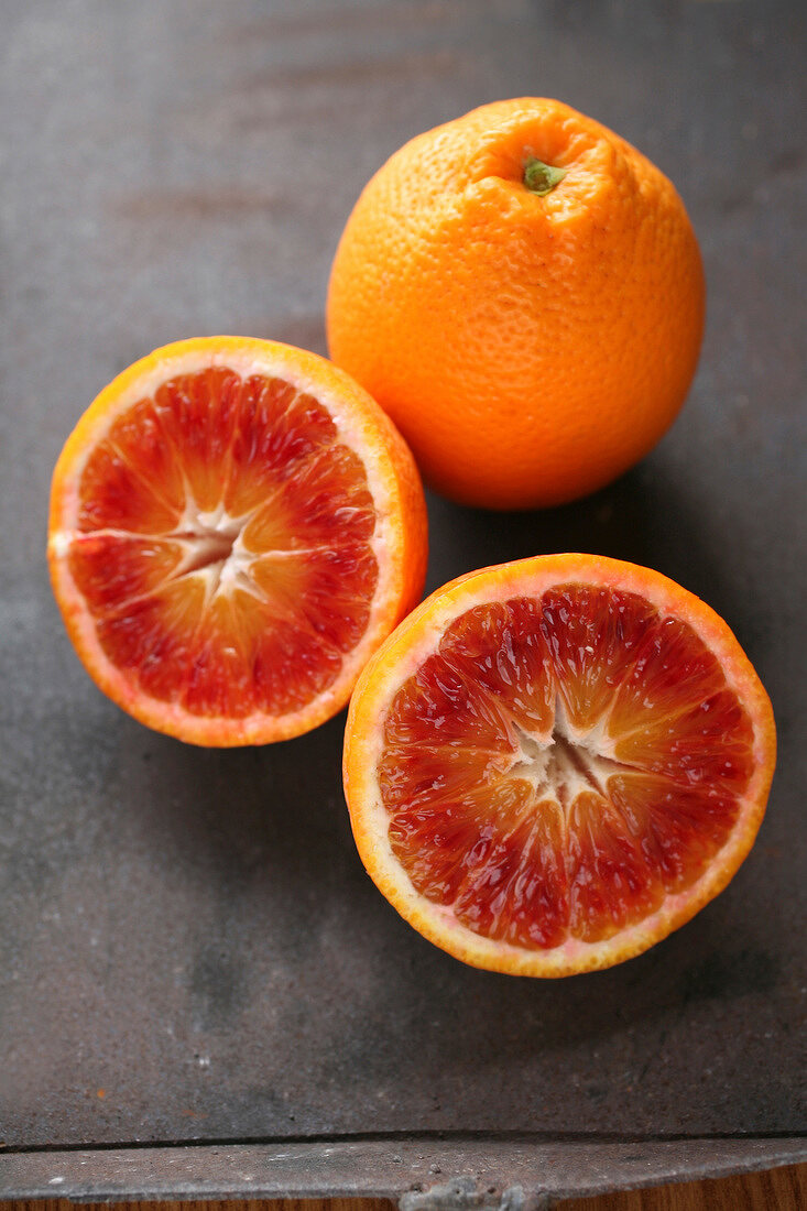 Close-up of whole and halved blood oranges