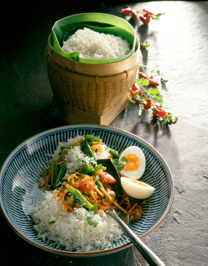 Roasted vegetable with rice, eggs, beans, carrots and tomatoes in bowl