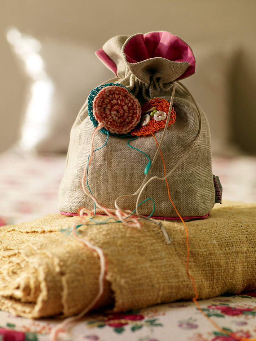 Close-up of small linen bag with crochet flowers