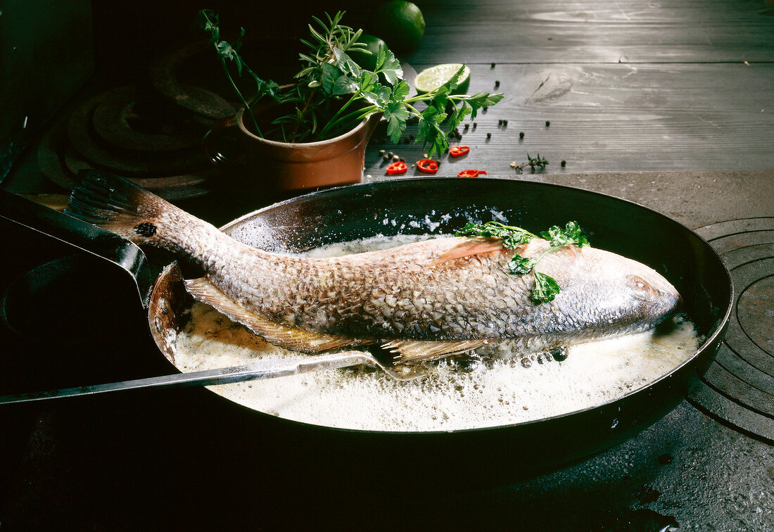 Croaker cooked with butter and herbs in pan