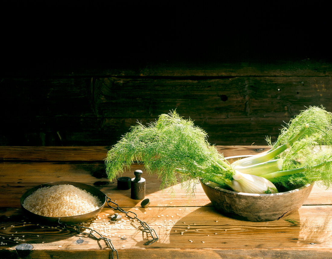 Ingredients of fennel risotto with rice and fennel on wooden table