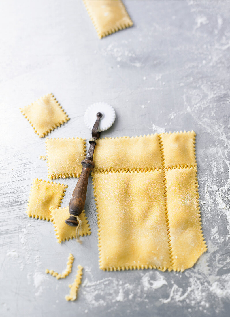 Rolled out dough cut in shaped pieces to prepare ravioli