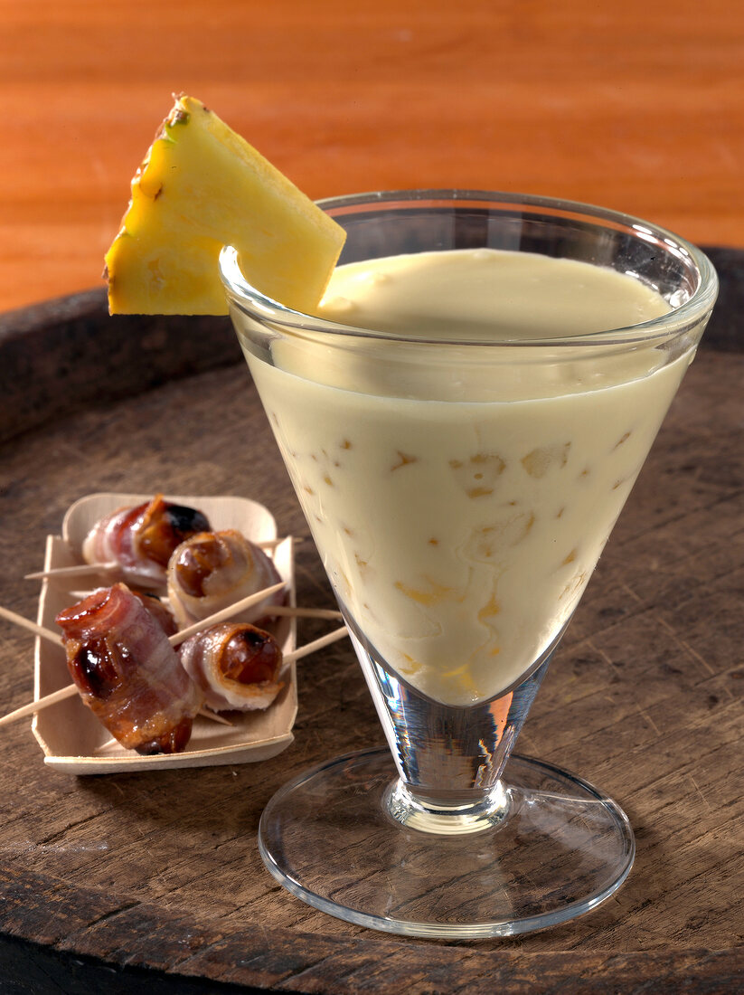 Pina colada in glass and datteln bacon on plate
