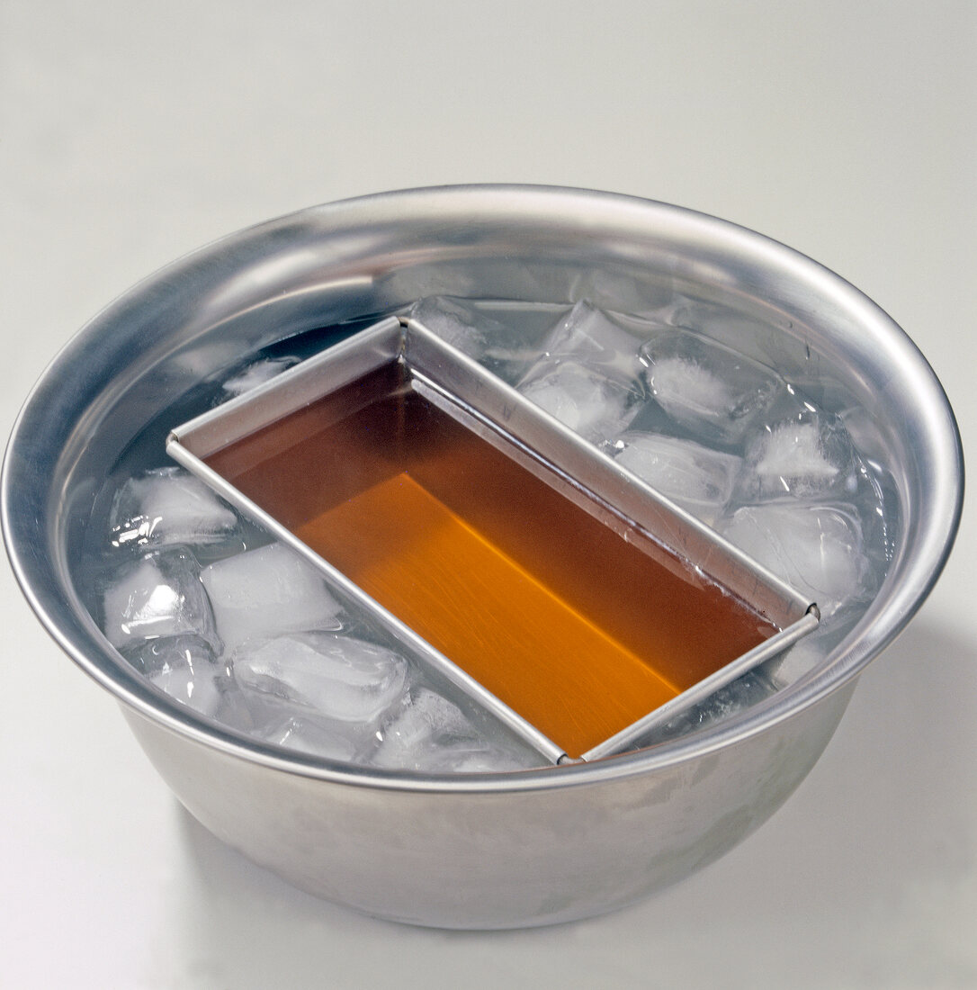 Jelly being formed while placed in ice filled bowl for preparing fish aspic, step 2