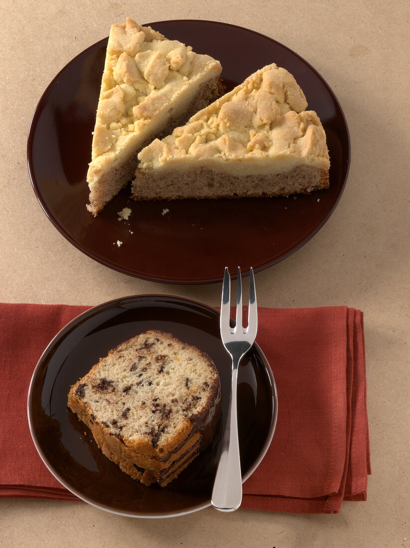 Pieces of nut streusel cake and vanilla wreath cake on plates