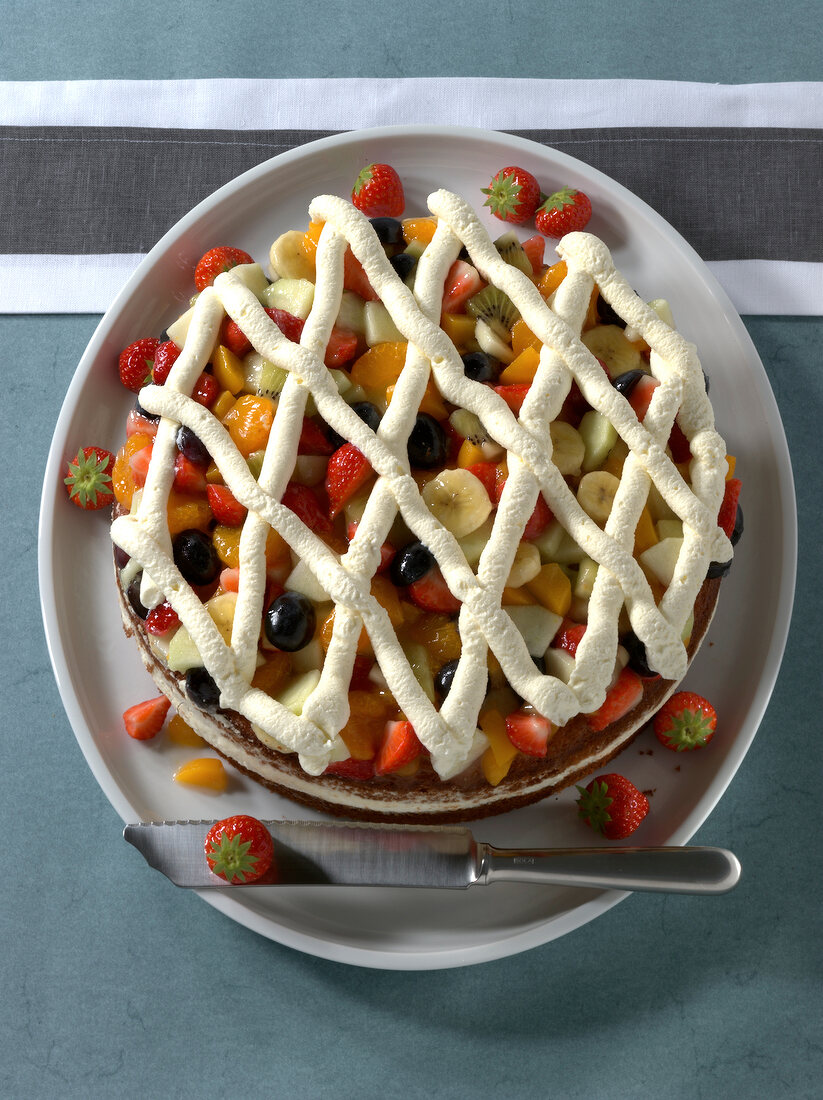 Fruit salad cake with cream on plate