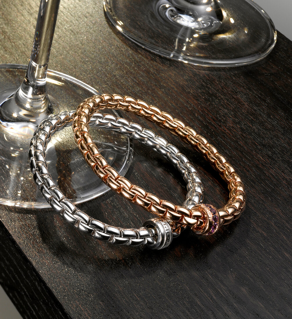 Two valuable luxury bracelets next to glasses