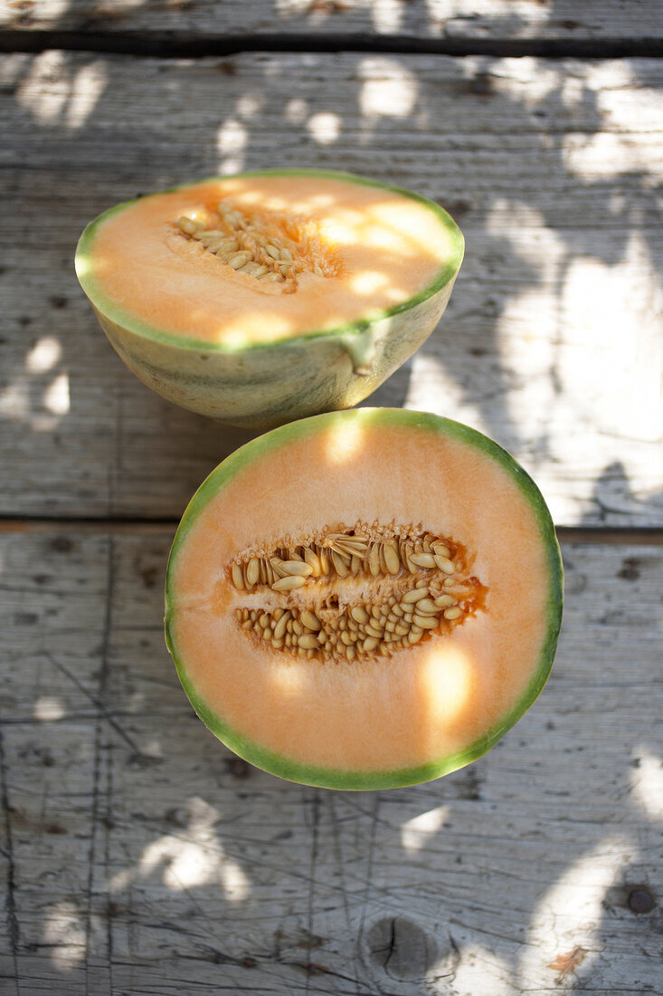 Halved galia melon on wooden surface