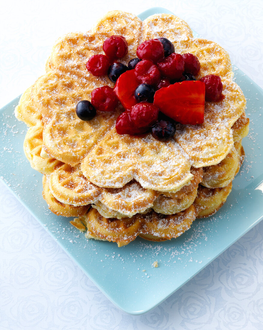 Waffles with berry salad and powdered sugar on plate