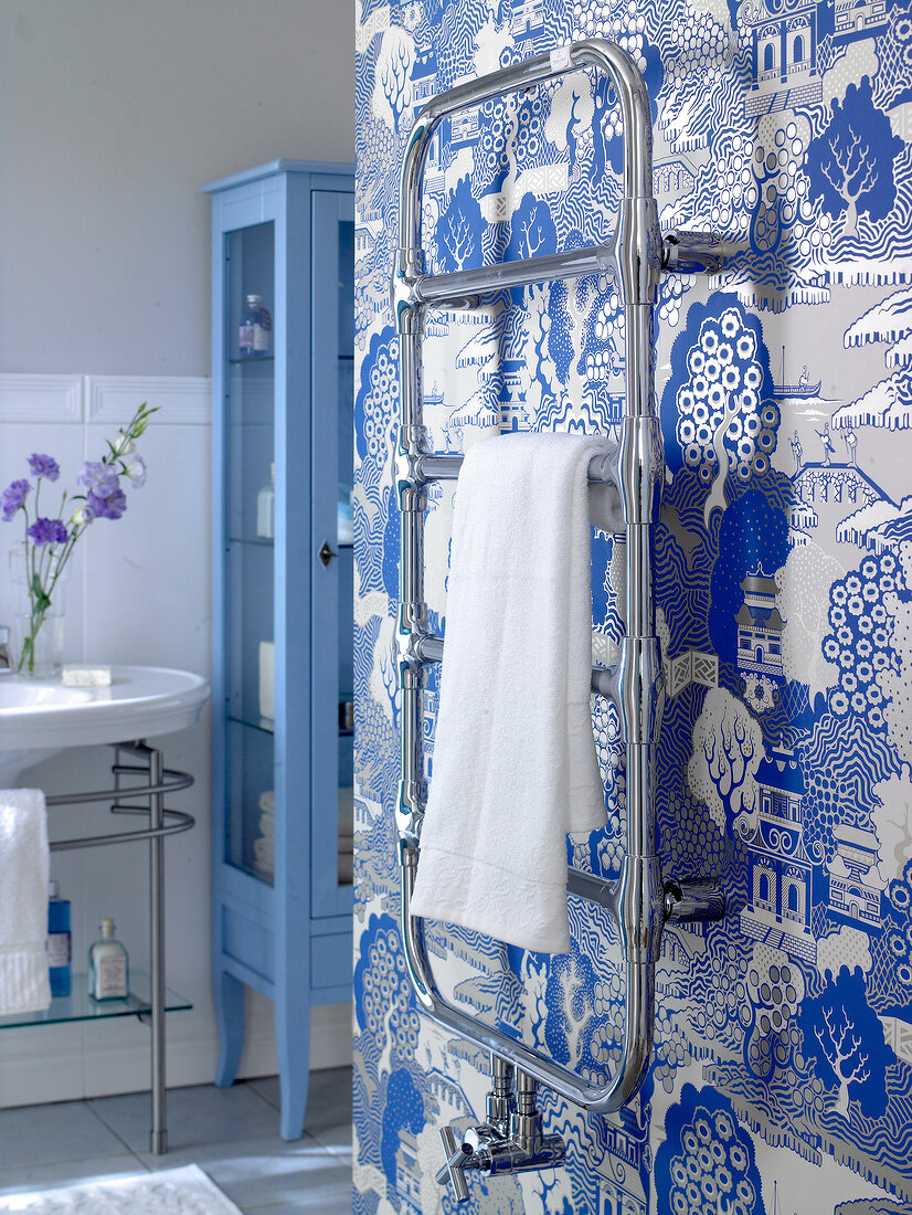 Bathroom with sink, blue cabinet and towel hanger against Asian style silver wallpaper