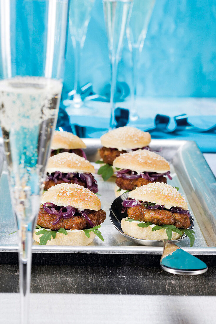 Meatballs, onion and arugula in sesame seed bun on tray