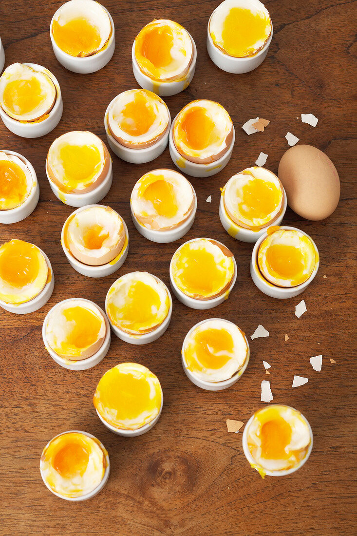 Soft boiled eggs with egg shells in egg cups