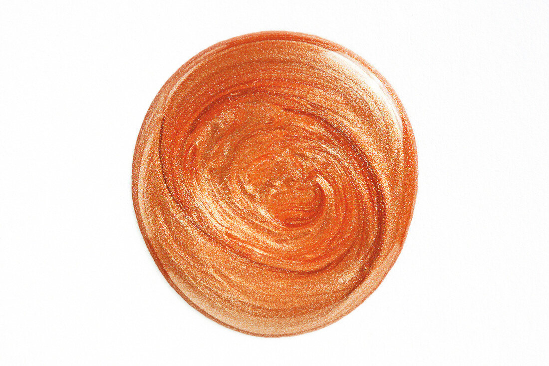 Blob of rust coloured nail polish on white background