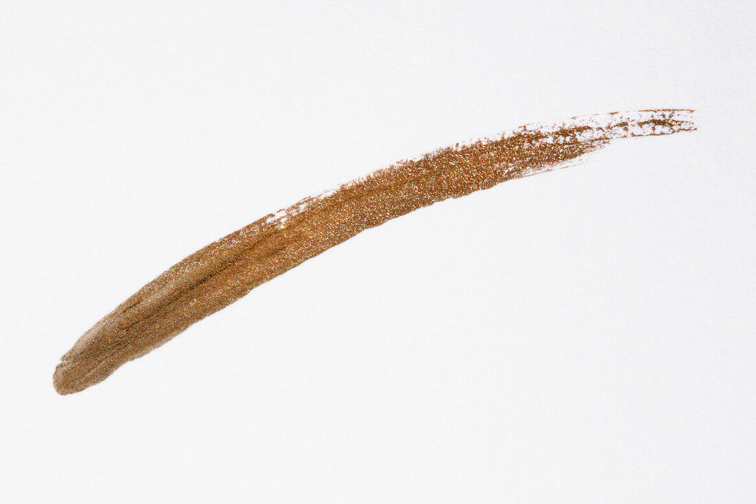Close-up of scribbled brown eyeliner on white background