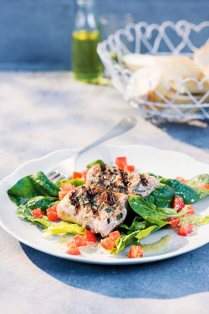 Close-up of grilled ham with sage and lemon on plate